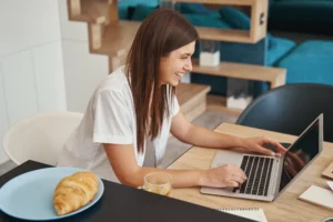 joyful-remote-worker-sitting-at-her-laptop